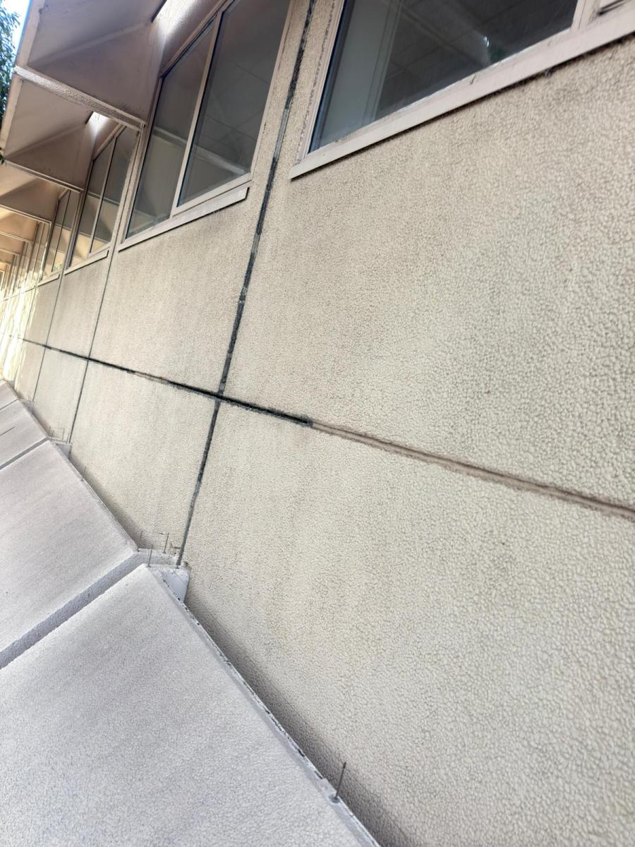 Commercial building exterior showing weathered wall caulking and sealant joints requiring professional maintenance