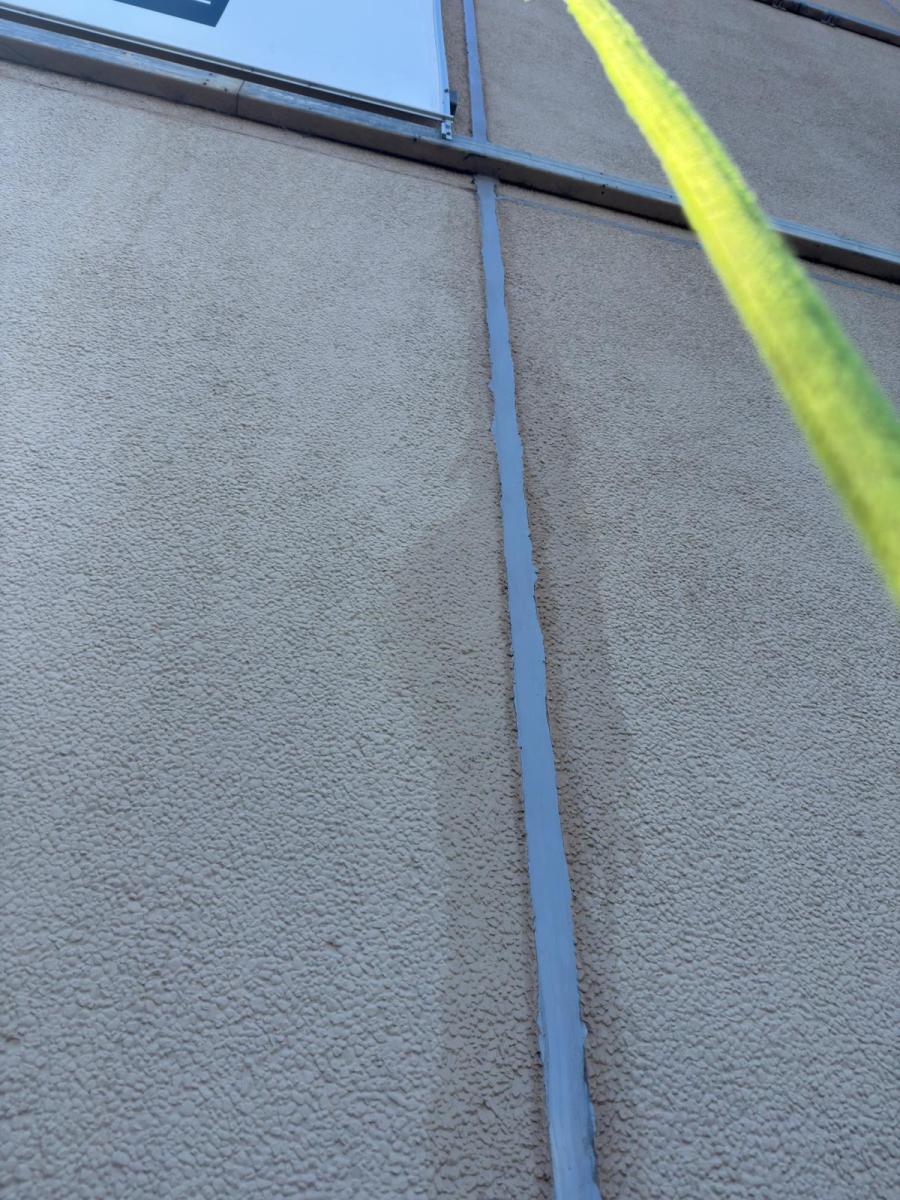 Close-up of deteriorated building caulking between concrete panels requiring professional maintenance