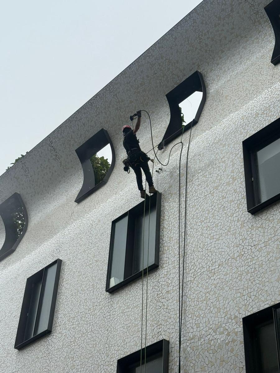 Rope access technician working on a multi-storey building facade